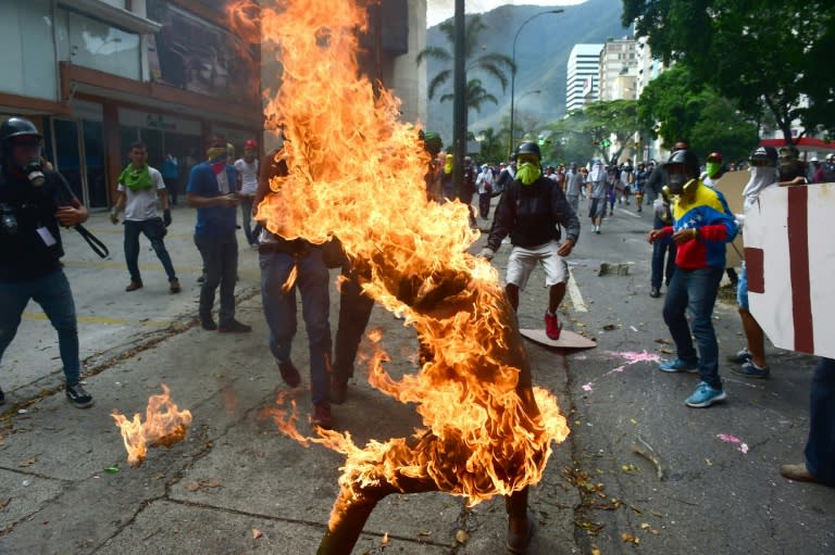 A demonstrator catches fire after the gas tank of a police motorbike exploded during clashes in a protest against Venezuelan President Nicolas Maduro, in Caracas on May 3, 2017