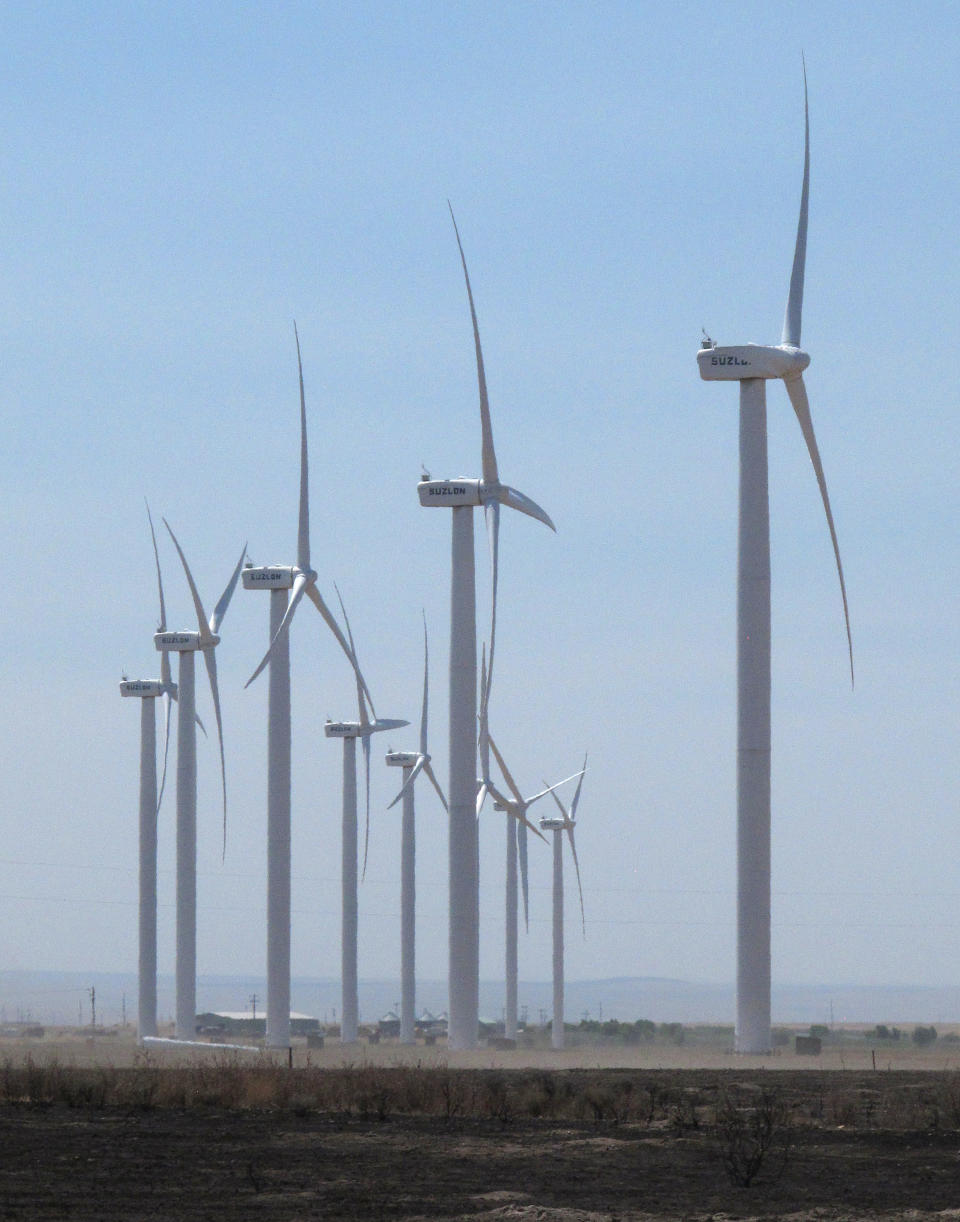 Wind turbines owned by Chicago-based Exelon Corp. turn on Thursday, Aug. 2, 2012 near Mountain Home, Idaho, above a field charred by a recent wildfire. State electricity regulators aiming to set the course for Idaho's renewables industry for years to come will hold hearings next week on long-running and bitter disputes between utilities like Idaho Power Co. and independent wind, solar and biogas developers. The Idaho Public Utilities Commission has scheduled three days of hearings starting Tuesday, to be attended by a crowd of lawyers, utility executives and environmentalists. (AP Photo/John Miller)