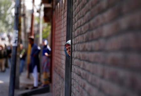 A woman looks out from a door during a protest in Srinagar, against the recent killings in Kashmir region, September 25, 2016. REUTERS/Danish Ismail