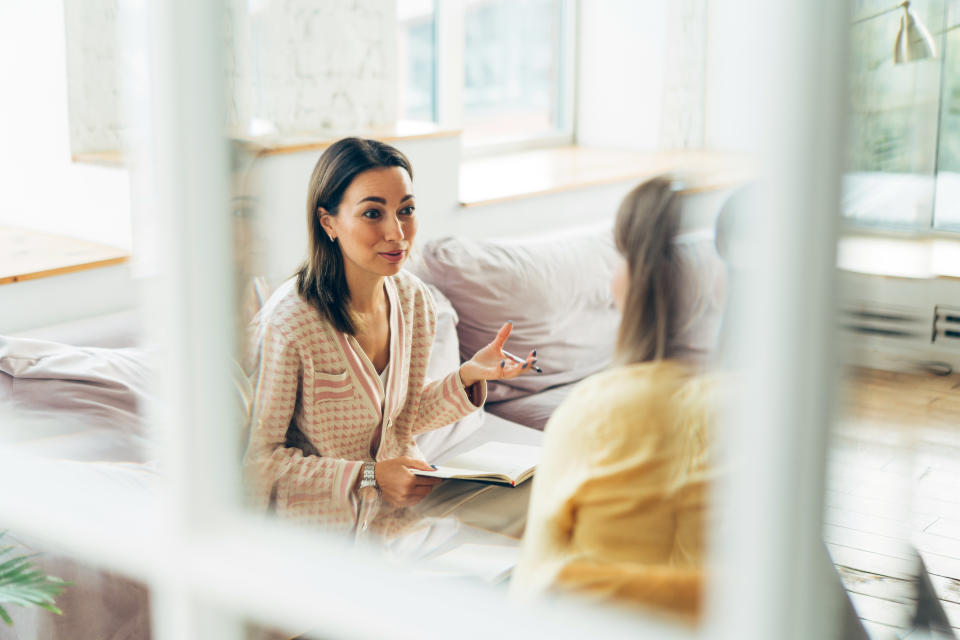 trauma Two women sitting in armchairs and talking. Woman psychologist talking to patient woman. Coach giving hands to writing woman. Therapist's gestures. Female talking in coworking office