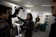 A staff member at the Malaysian Airlines' office in Beijing's International Airport reacts to journalists in Beijing, China, Saturday, March 8, 2014. A Malaysia Airlines Boeing 777-200 carrying 239 people lost contact with air traffic control early Saturday morning on a flight from Kuala Lumpur to Beijing, and international aviation authorities still hadn't located the jetliner several hours later. (AP Photo/Ng Han Guan)