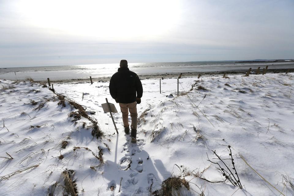 Innkeeper Ken Mason surveys the damage caused by the recent storm that wiped out the seawall, stairs and sand dunes in front of the Seaside Inn.