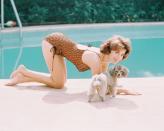 <p>Natalie Wood plays with her poodle before taking a dip in her swimming pool in 1970. </p>