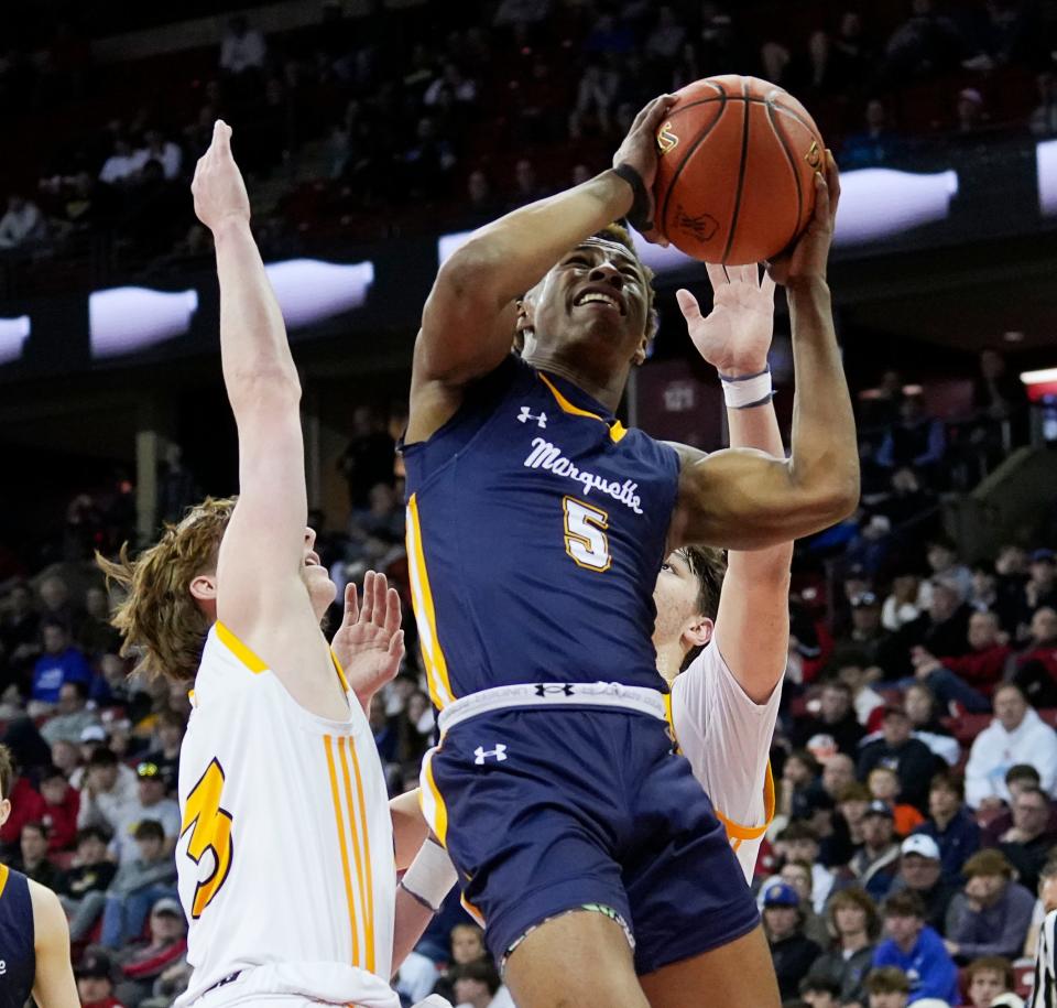 Marquette's Tommy Novotny (5) scores as Kettle Moraine's Will Stuckey (3) and Roman Thompson (23) attempted to block him during the first half of the WIAA Division 1 boys basketball state semifinal game on Friday March 15, 2024 at the Kohl Center in Madison, Wis.