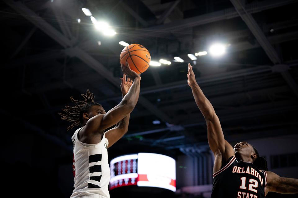 Cincinnati Bearcats guard Jizzle James (2) hits a basket over Oklahoma State Cowboys guard Javon Small (12) Wednesday. The Bearcats dropped a winnable game against the Cowboys that could have helped their postseason chances.