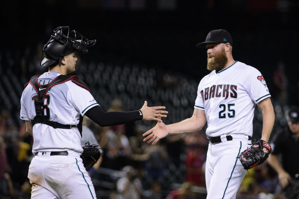 Sep 3, 2019; Phoenix, AZ, USA; Arizona Diamondbacks catcher Carson Kelly (18) and relief pitcher Archie Bradley (25) celebrate after closing out the game against the San Diego Padres at Chase Field. Mandatory Credit: Jennifer Stewart-USA TODAY Sports