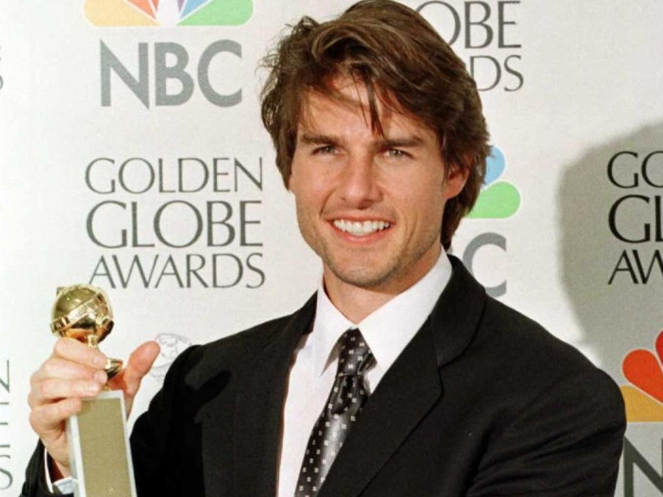 Tom Cruise holding a Golden Globe award (AFP via Getty Images)