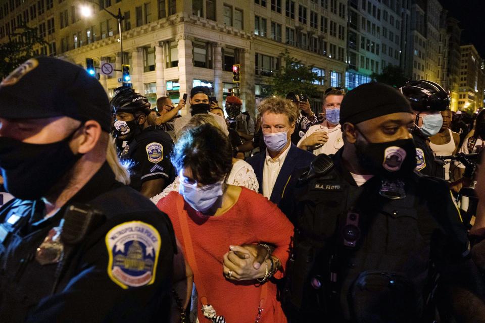 Sen. Rand Paul, R-Ky., center, and others, are escorted by Metropolitan Police after attending President Donald Trump's acceptance speech at the White House, Thursday night , Aug. 27, 2020, in Washington.