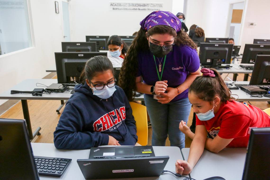Kaylla Torres, lead instructor and program coordinator at Code/Art, a nonprofit that teaches coding skills to young girls, helps her students with their classwork at the offices of the nonprofit in Miami, Florida, on Monday, Oct. 4, 2021.