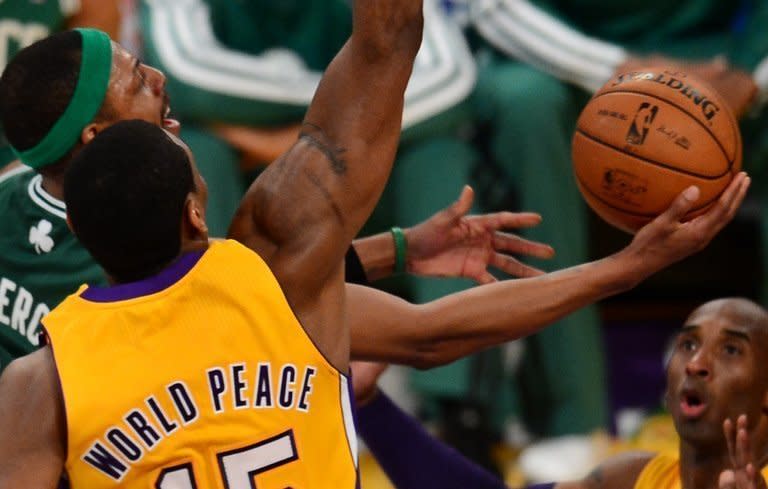 Paul Pierce (L) of the Boston Celtics goes to the basket against Metta World Peace (C) and Kobe Bryant of the LA Lakers, on February 20, 2013. The Lakers won in their first game since their long-time owner Jerry Buss died, beating the Celtics 113-99