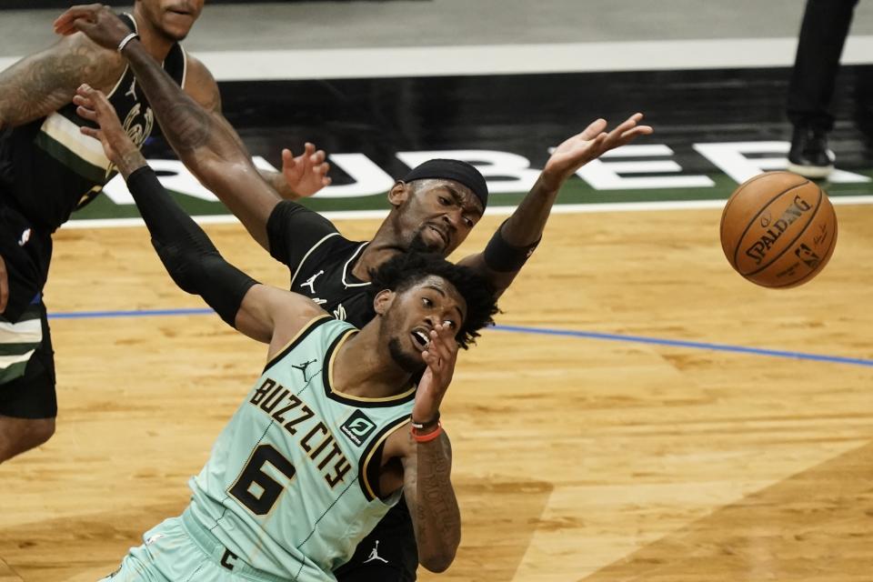 Charlotte Hornets' Jalen McDaniels and Milwaukee Bucks' Bobby Portis go after a loose ball during the first half of an NBA basketball game Friday, April 9, 2021, in Milwaukee. (AP Photo/Morry Gash)