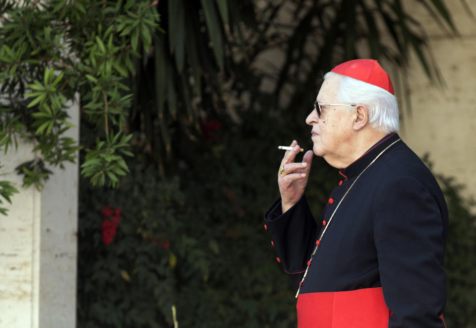 Cardinal Jose' Policarpo smokes during a pause of the morning session of an extraordinary consistory in the Synod hall at the Vatican City, Friday, Feb. 21, 2014. Pope Francis is leading a two-day meeting urging his cardinals to find "intelligent, courageous" ways to help families under threat today without delving into case-by-case options to get around Catholic doctrine. He said the church must find ways to help families with pastoral care that is "full of love."(AP Photo/Alessandra Tarantino)