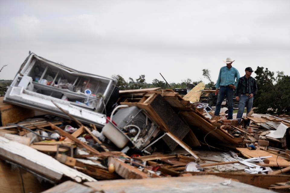 Residents pick up debris after a tornado, Thursday, June 22, 2023, in Matador, Texas. 