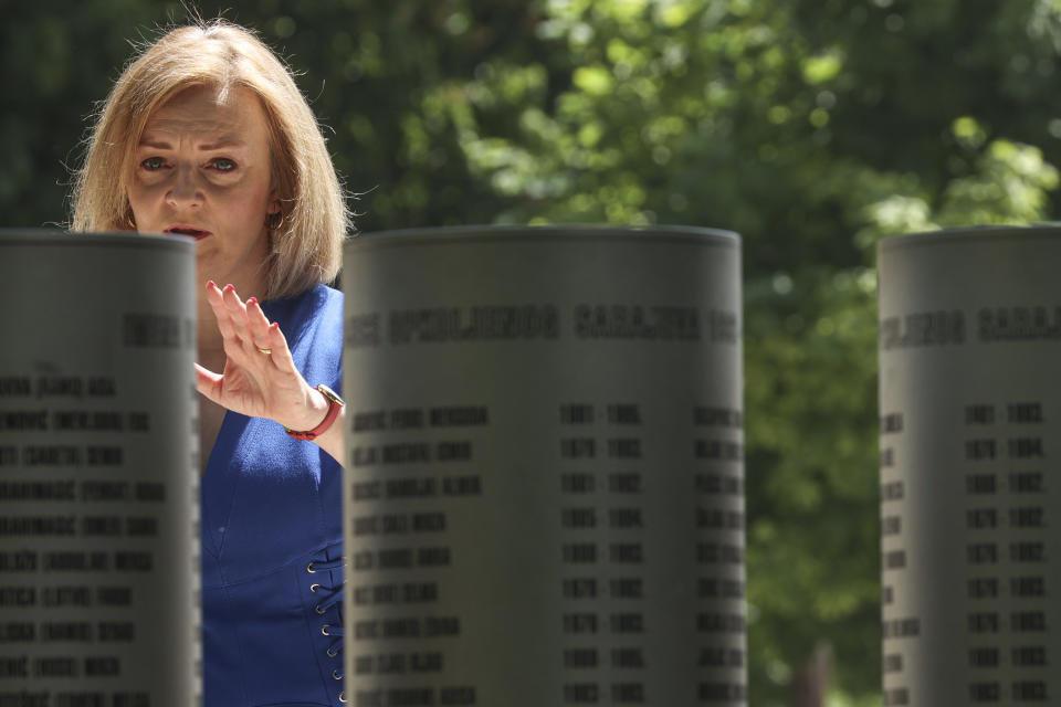 Elizabeth Truss, Britain's Secretary of State for Foreign, Commonwealth and Development Affairs, gestures looking at pillars bearing names of victims at a monument dedicated to the children killed during the Bosnian war in the besieged Bosnian capital in Sarajevo, Bosnia, Thursday, May 26, 2022. (AP Photo/Armin Durgut)