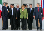 FILE - German Chancellor Angela Merkel, center, is surrounded by other leaders as they walk to pose for a photo in Heiligendamm, Germany, June 7, 2007. The leaders include U.S. President George W. Bush, Italian Premier Romano Prodi, Japanese Premier Shinzo Abe, Russian President Vladimir Putin, French President Nicolas Sarkozy, EU Commission President Jose Manuel Barroso, British Premier Tony Blair and Canadian Premier Stephen Harper. As chancellor, Merkel has been credited with raising Germany’s profile and influence, helping hold a fractious European Union together, managing a string of crises and being a role model for women in a near-record tenure. (AP Photo/Michael Probst, File)