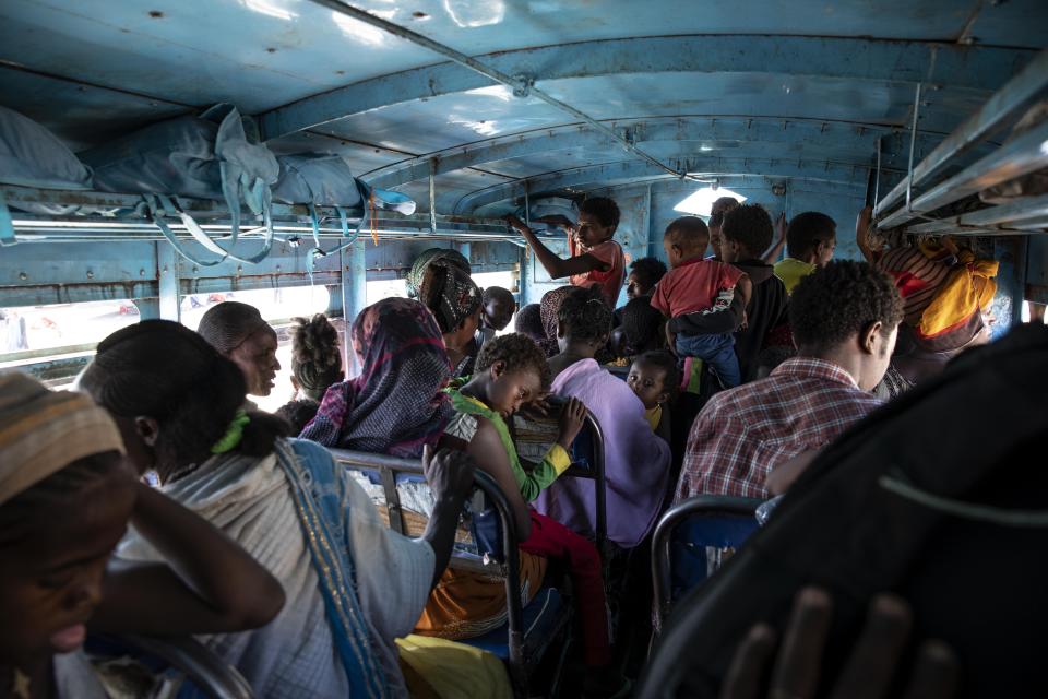 Tigray refugees who fled the conflict in the Ethiopia's Tigray ride a bus going to the Village 8 temporary shelter, near the Sudan-Ethiopia border, in Hamdayet, eastern Sudan, Tuesday, Dec. 1, 2020. (AP Photo/Nariman El-Mofty)