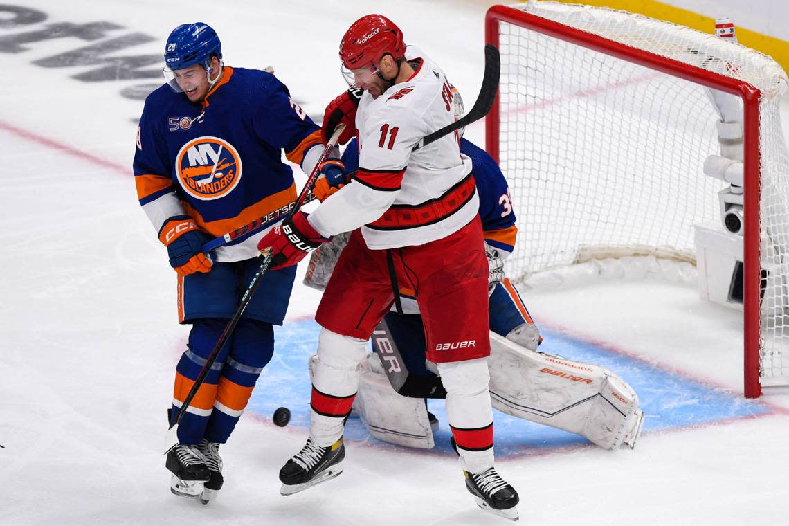 New York Islanders defenseman Alexander Romanov (28) and Carolina Hurricanes center Jordan Staal (11) battle in front of Islanders goaltender Ilya Sorokin (30) during the third period in game three of the first round of the 2023 Stanley Cup Playoffs at UBS Arena.