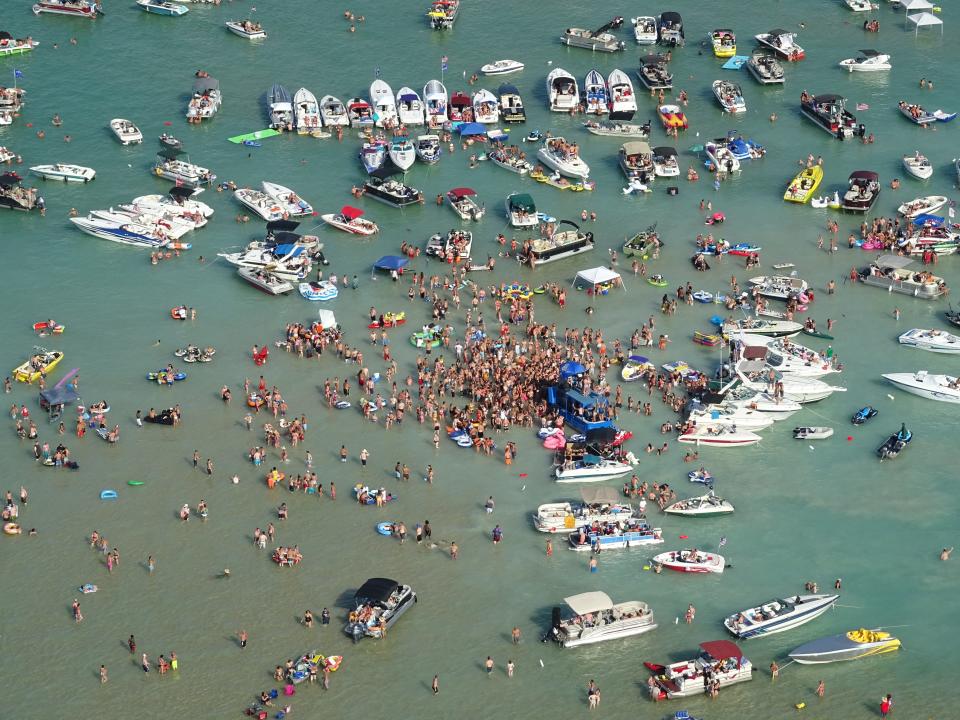 Anyone who attended a Fourth of July party at Torch Lake Sandbar over the holiday weekend is being asked to monitor themselves for symptoms after several attendees tested positive.