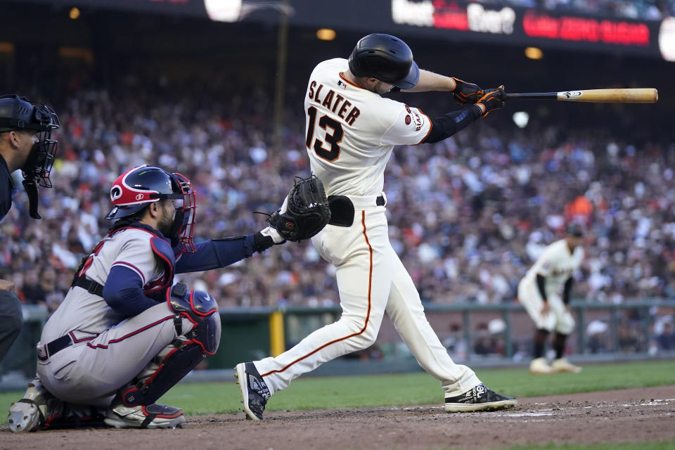 San Francisco Giants' Austin Slater (13) hits an RBI single in front of Atlanta Braves catcher Travis d'Arnaud during the sixth inning of a baseball game in San Francisco, Sunday, Aug. 27, 2023. (AP Photo/Jeff Chiu)
