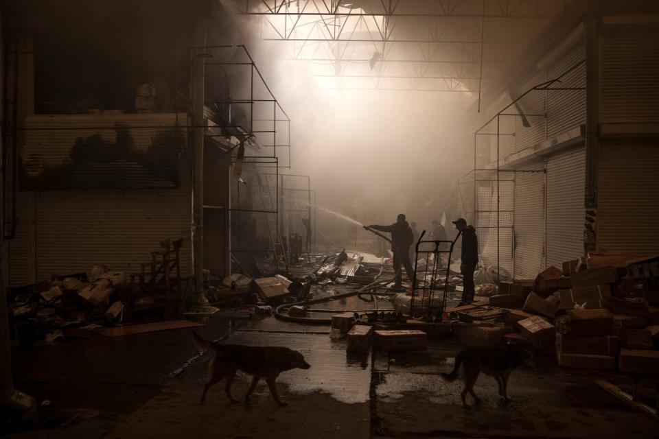 People try to extinguish a fire in a market after a Russian attack in Kharkiv on Friday (AP)