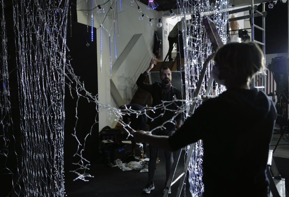 French designer Julien Fournie, center, gives instructions to decorators during the shoot for his Haute Couture Spring/Summer 2021 fashion collection for a digital presentation of the fashion week, in Paris, Thursday, Jan. 7, 2021. With shows taking place behind closed doors due to the virus pandemic, some designers such as Julien Fournie are becoming versatile: Getting their designs out to the public by making a film of their collection and streaming it online. (AP Photo/Francois Mori)