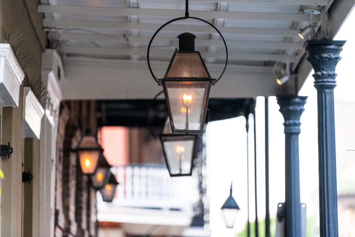 New Orleans typical street covered sidewalk with row of flame in gas lanterns lamps in Louisiana