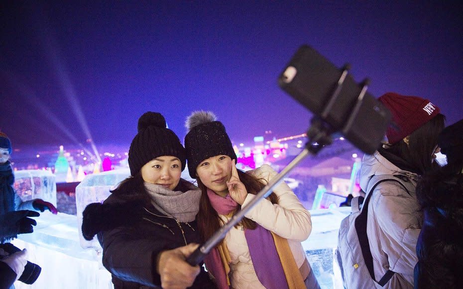 <p>Visitors take a selfieat theIce and Snow Festival in Harbin.</p>