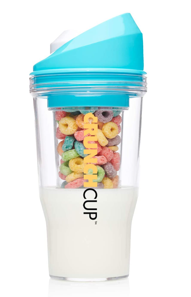 The Crunch Cup is pictured with its blue lid and transparent lower case which includes two cups, an outer one for milk and an inner one for cereal.