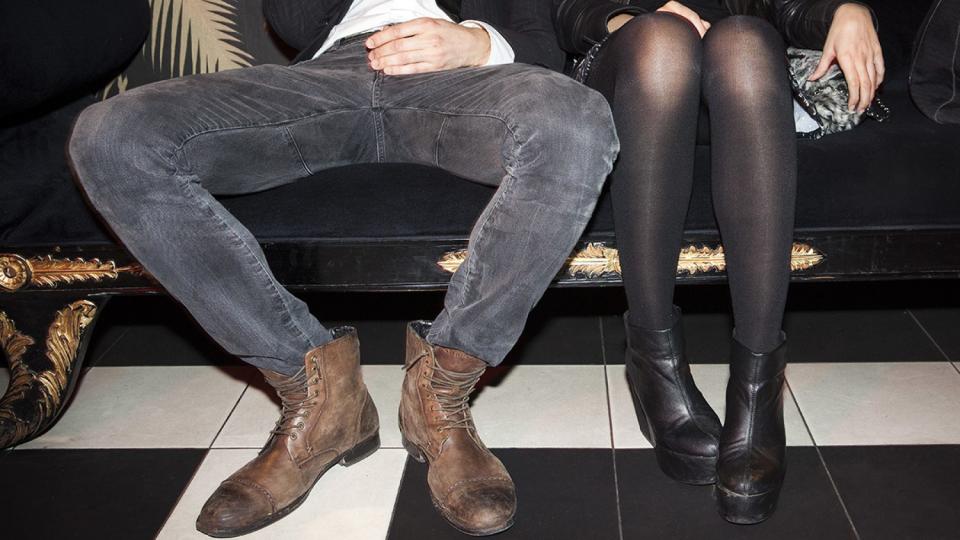 Young couple sitting side by side at night club (Photo credit: Getty Images)