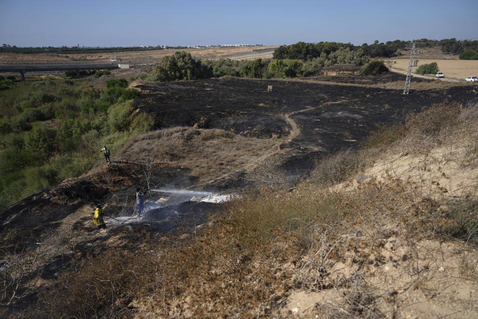 Firefighters work to extinguish fires set by incendiary ballons launched from the Gaza Strip, setting vegetation ablaze near the Israel-Gaza border, Friday, Sept. 22, 2023. Tensions between Israel and Gaza have risen in recent days as Palestinians have staged violent protests near the fence demarcating the territory. (AP Photo/Tsafrir Abayov)