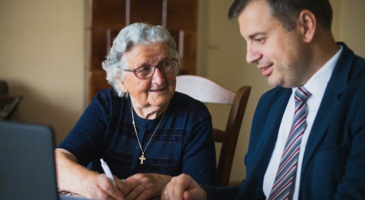 Elderly home owner signs her will in front of a lawyer