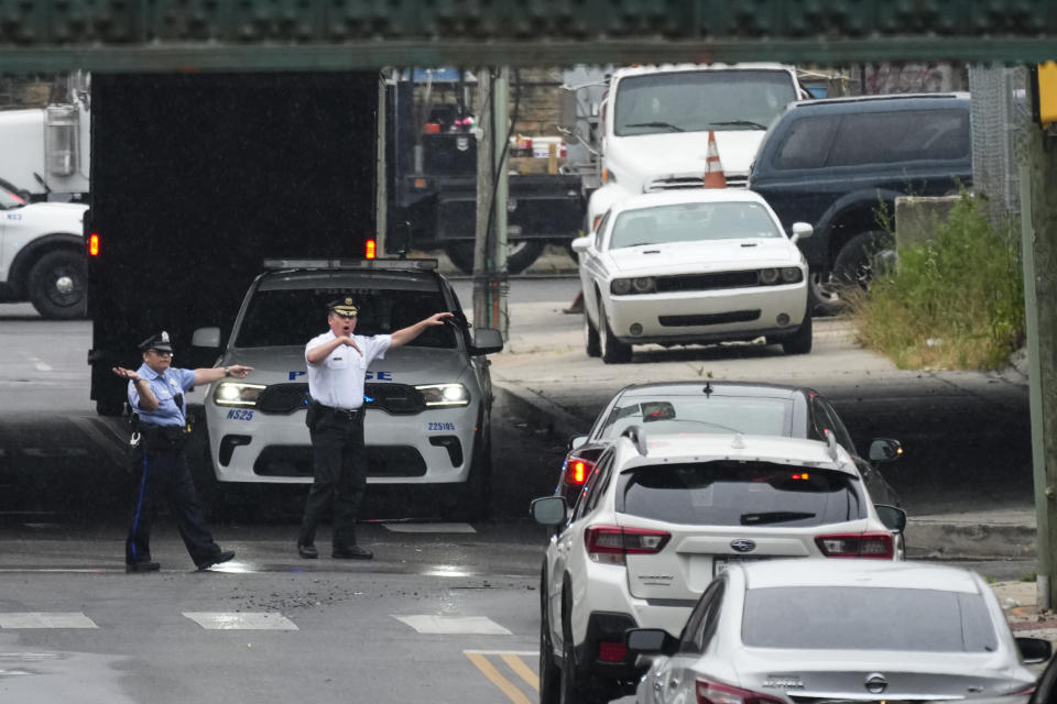 Officers direct traffic detoured in Philadelphia, Monday, June 12, 2023. Drivers began longer commutes Monday after a section of I-95 collapsed a day earlier following damage caused by a tanker truck carrying flammable cargo catching fire. (AP Photo/Matt Rourke)