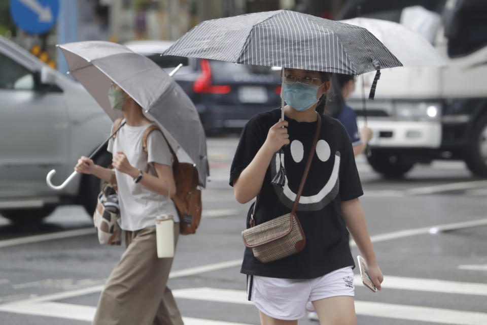 Gente caminando bajo la lluvia ante la llegada del tifón Hinnamnor en Taipéi, Taiwán, el sábado 3 de septiembre de 2022. (AP Foto/Chiang Ying-ying)