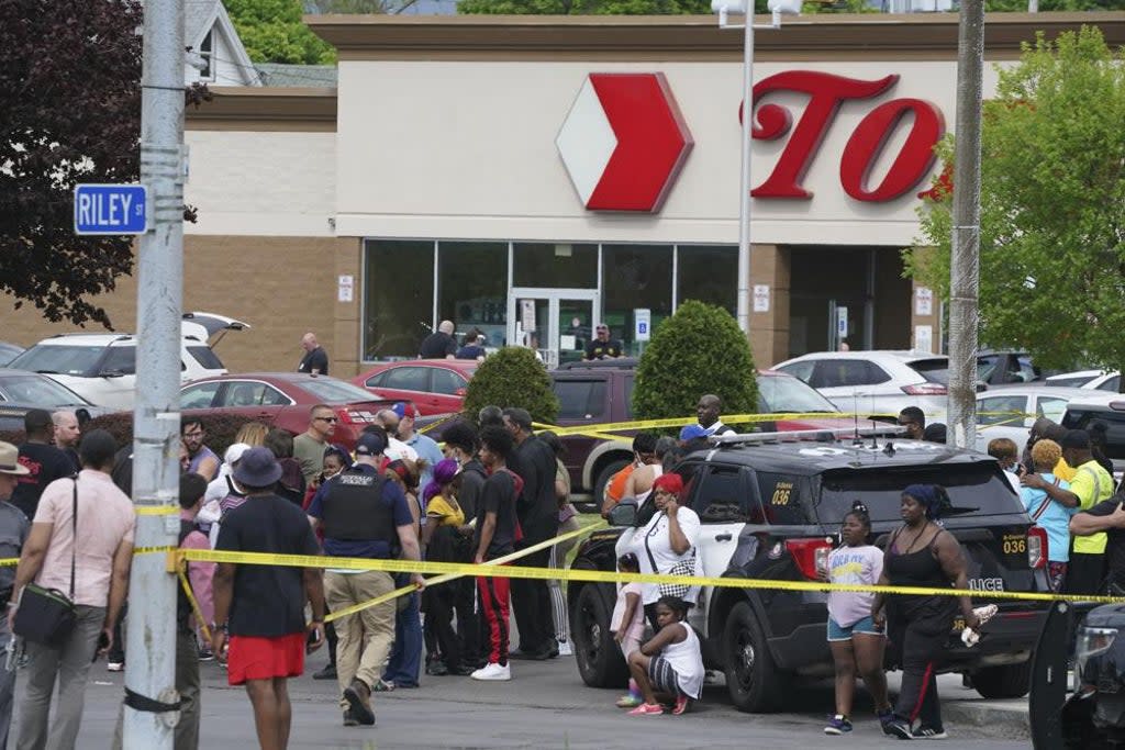 People gather outside a supermarket where several people were killed in a shooting, Saturday in Buffalo  (Associated Press)