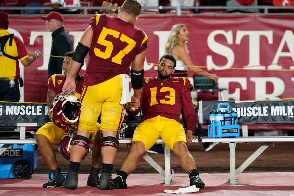 Southern California quarterback Caleb Williams (13) reacts with offensive lineman Justin Dedich (57) and running back Austin Jones after the team's loss to Utah last week. Williams did not shake hands with Utah after the game.