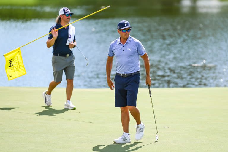  Rickie Fowler sale del green del noveno hoyo mientras el nuevo caddie Ben Schomin sostiene la bandera durante la práctica para el FedEx St. Jude, el primer playoffs de la FedExCup, en TPC Southwind 