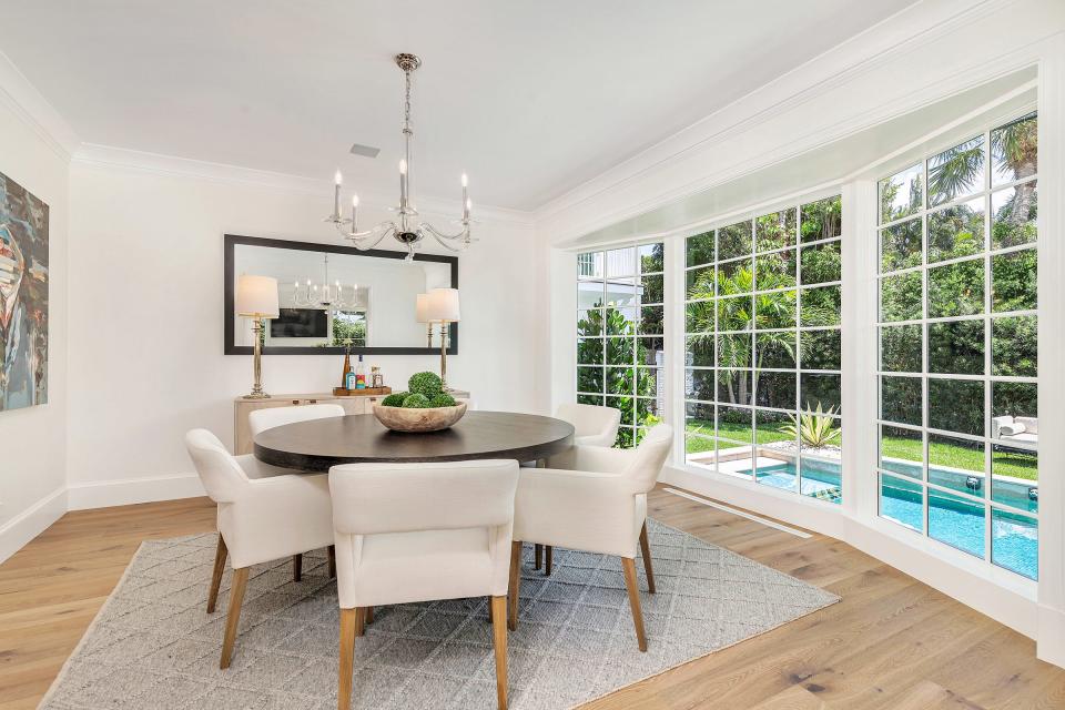 The dining area looks out a floor-to-ceiling bow window in an updated 1940s-era house at 236 Pendleton Ave. The house is listed at just under $15 million.