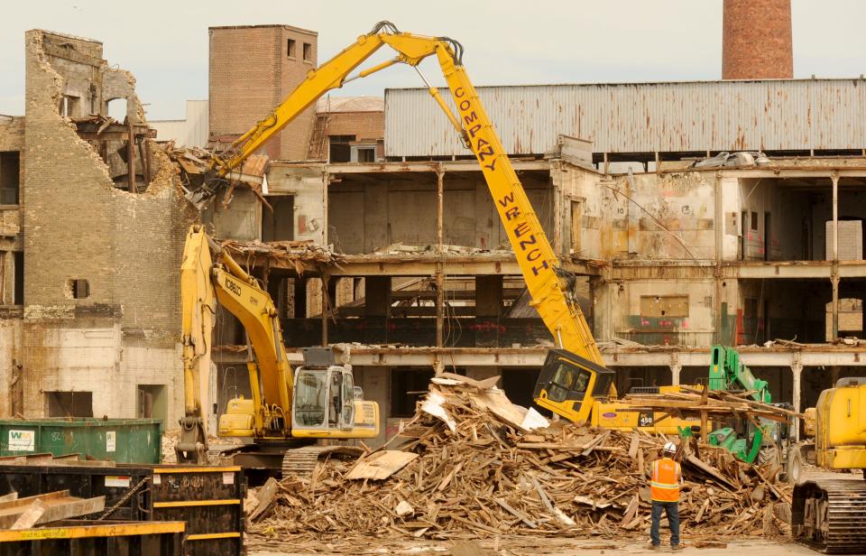 A crew salvages scrap metal during the demolition of one of the factories at the former Hamilton Manufacturing complex/Thermo Fisher Scientific in Two Rivers, August 26, 2014. A portion of the iconic smokestack can be seen on the right.