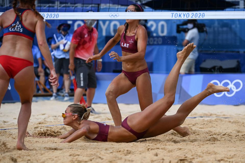 <p>Latvia's Tina Graudina (C) falls in the sand in their women's preliminary beach volleyball pool D match between the USA and Latvia during the Tokyo 2020 Olympic Games at Shiokaze Park in Tokyo on July 26, 2021. (Photo by ANGELA WEISS / AFP)</p> 