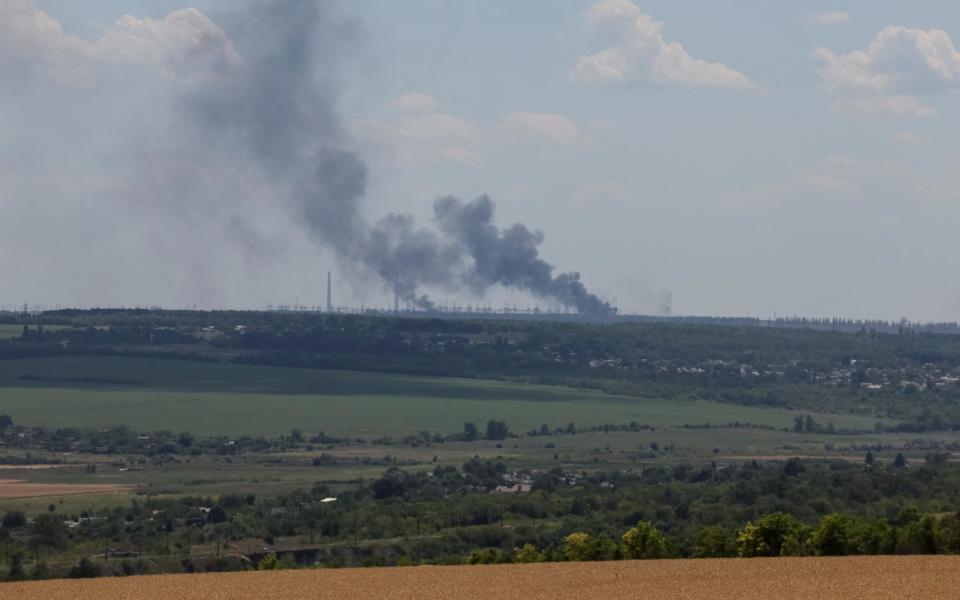 Vuhlehirsk power plant burns in the distance - Reuters