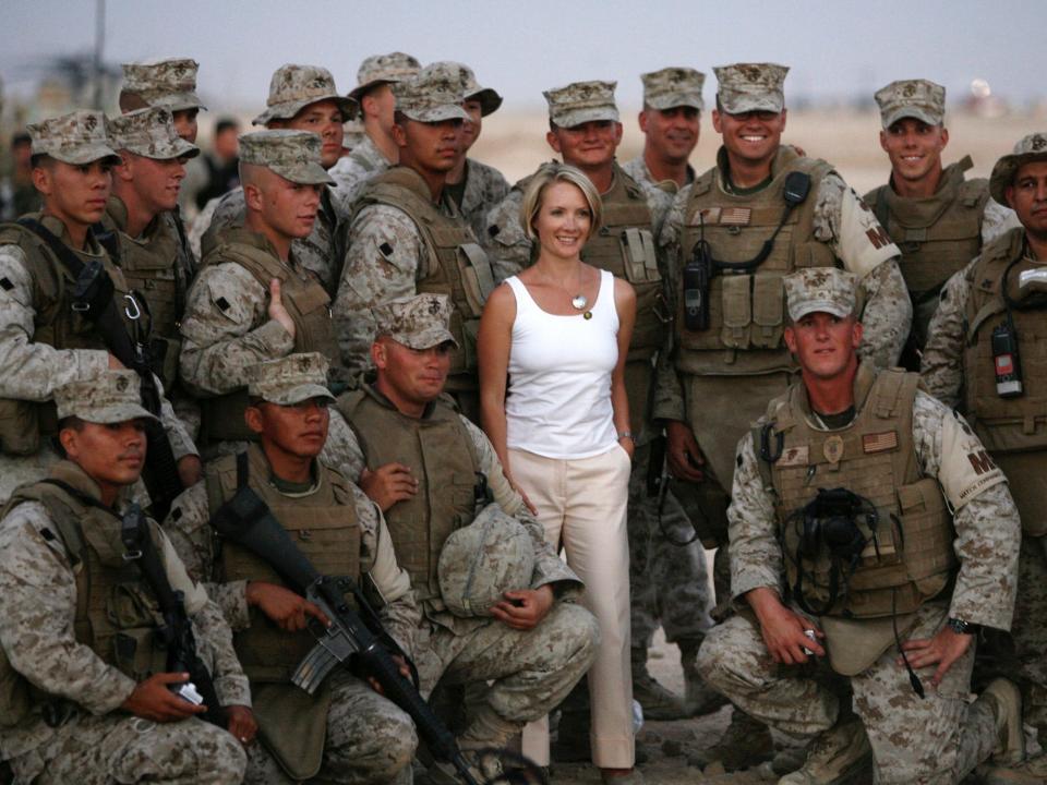 Newly promoted White House Press Secretary Dana Perino poses with U.S. Marines during a visit to Al-Asad airbase with U.S. President George W. Bush in Anbar Province September 3, 2007.