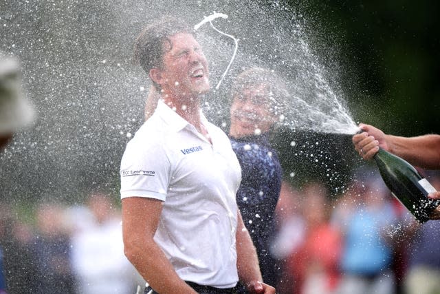 Niklas Norgaard is sprayed in the face with champagne