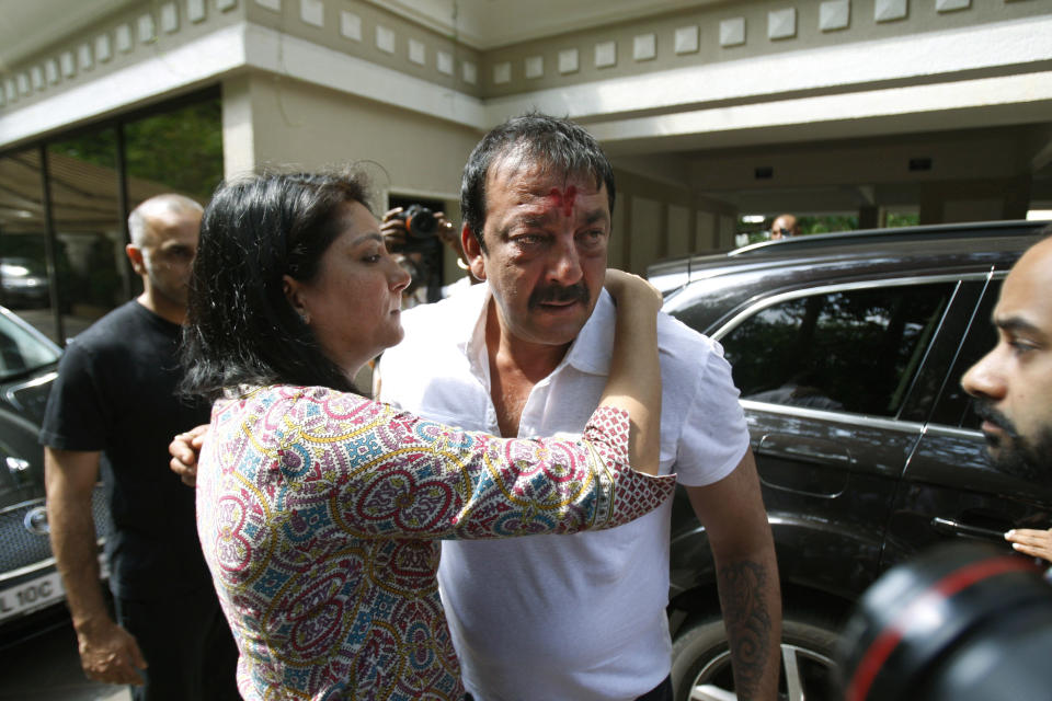 Priya Dutt tries to console her brother Indian Bollywood actor Sanjay Dutt, center, after he broke down during a press conference at his residence in Mumbai, India, Thursday, March 28, 2013. Dutt said he has not sought pardon for a 1993 weapons conviction and will serve his prison sentence as ordered by India's Supreme Court. Dutt broke his silence a week after the court sentenced him to five years in prison for illegal possession of weapons supplied by Mumbai crime bosses linked to a 1993 terror attack that killed 257 people.(AP Photo/Rafiq Maqbool)