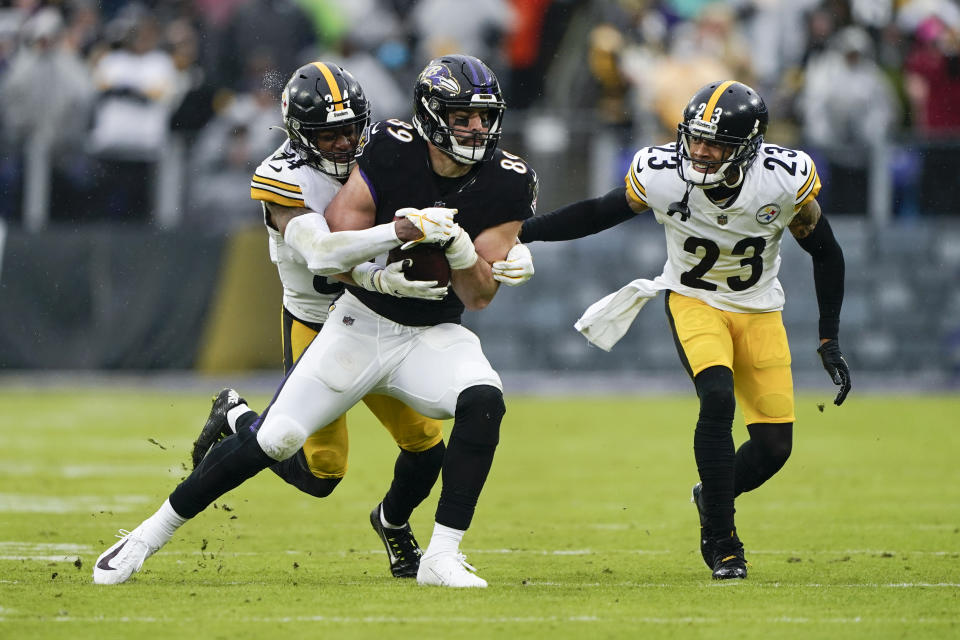 Baltimore Ravens tight end Mark Andrews, center, is hit by Pittsburgh Steelers safety Terrell Edmunds (34) as cornerback Joe Haden (23) looks on during the first half of an NFL football game, Sunday, Jan. 9, 2022, in Baltimore. (AP Photo/Evan Vucci)