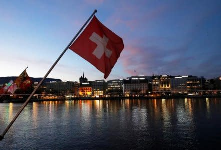 FILE PHOTO: A Swiss flag is pictured during the sunrise on the Commercial and Financial District in Geneva, Switzerland, November 23, 2017. REUTERS/Denis Balibouse