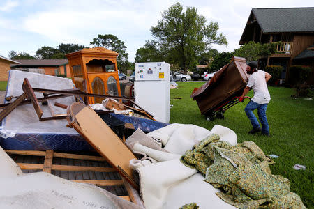 A man takes debris out of a flood-damaged house in the aftermath of Tropical Storm Harvey in Port Arthur, Texas, U.S. September 5, 2017. REUTERS/Jonathan Bachman