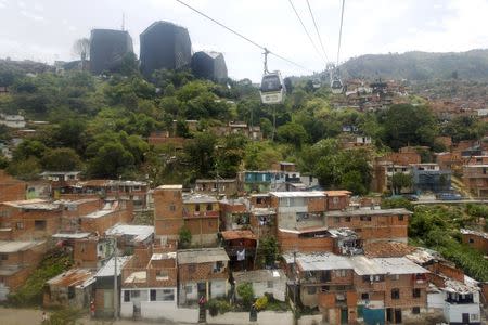 Cable cars of the Metrocable transport system are pictured over the "Comuna 1" neighborhood in Medellin September 8, 2015. REUTERS/Fredy Builes