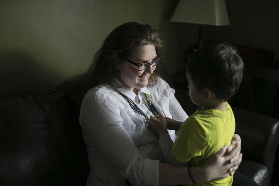 Tiffany Ann Stacy holds her son at home in Cuyahoga Falls, Ohio. Stacy, born in the U.S., lives with her husband from Nepal, their children and his parents.