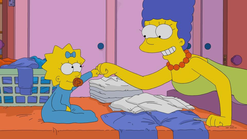 Marge and Maggie Simpson fist bump while folding laundry