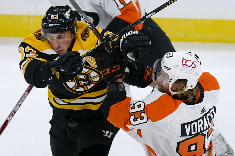 Boston Bruins center Brad Marchand (63) grapples with Philadelphia Flyers right wing Jakub Voracek (93) during the third period of an NHL hockey game Thursday, Jan. 21, 2021, in Boston. (AP Photo/Elise Amendola)